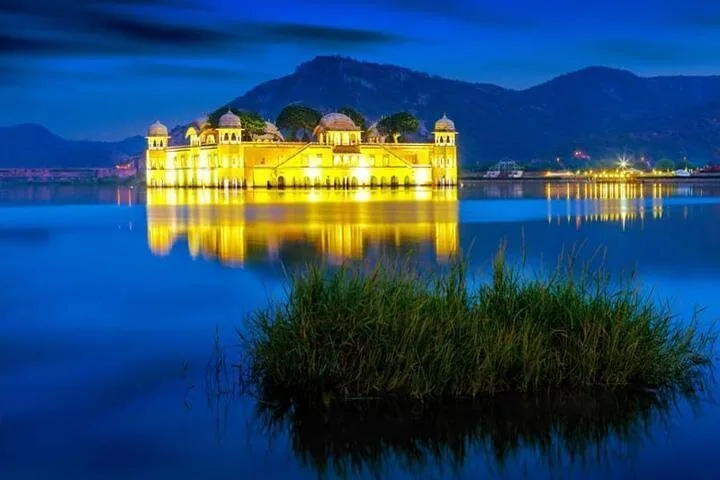 Il Jal Mahal illuminato d'oro sul lago Man Sagar al crepuscolo